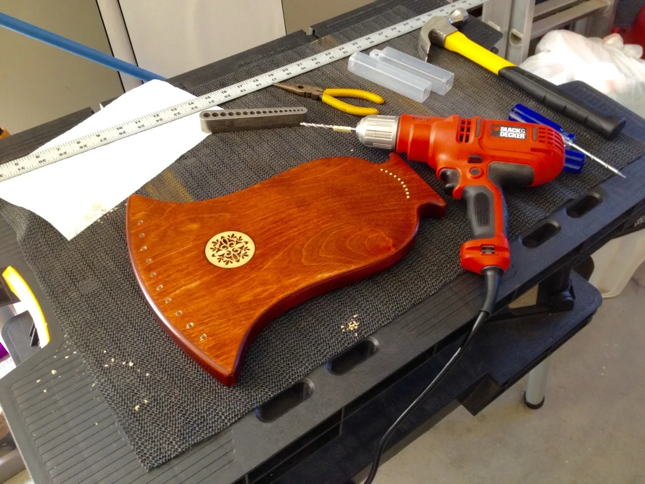 Handmade lyre construction: drilling for string installation